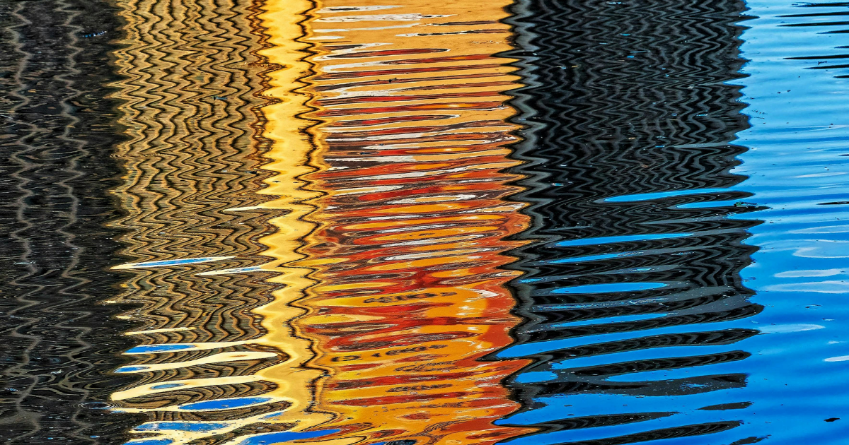Water reflection with wavy vertical bands of gold, orange, black, and bright blue to symbolise how managers can build reflection into their daily routine