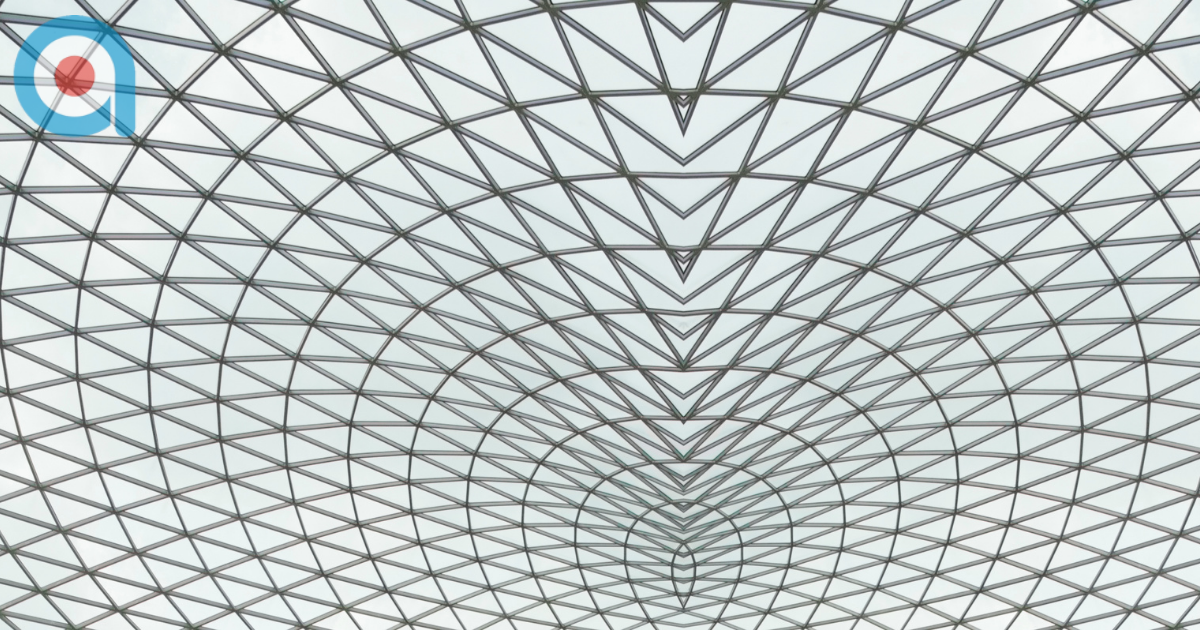 Geometric glass ceiling with repeating triangular metal framework forming a symmetrical pattern.