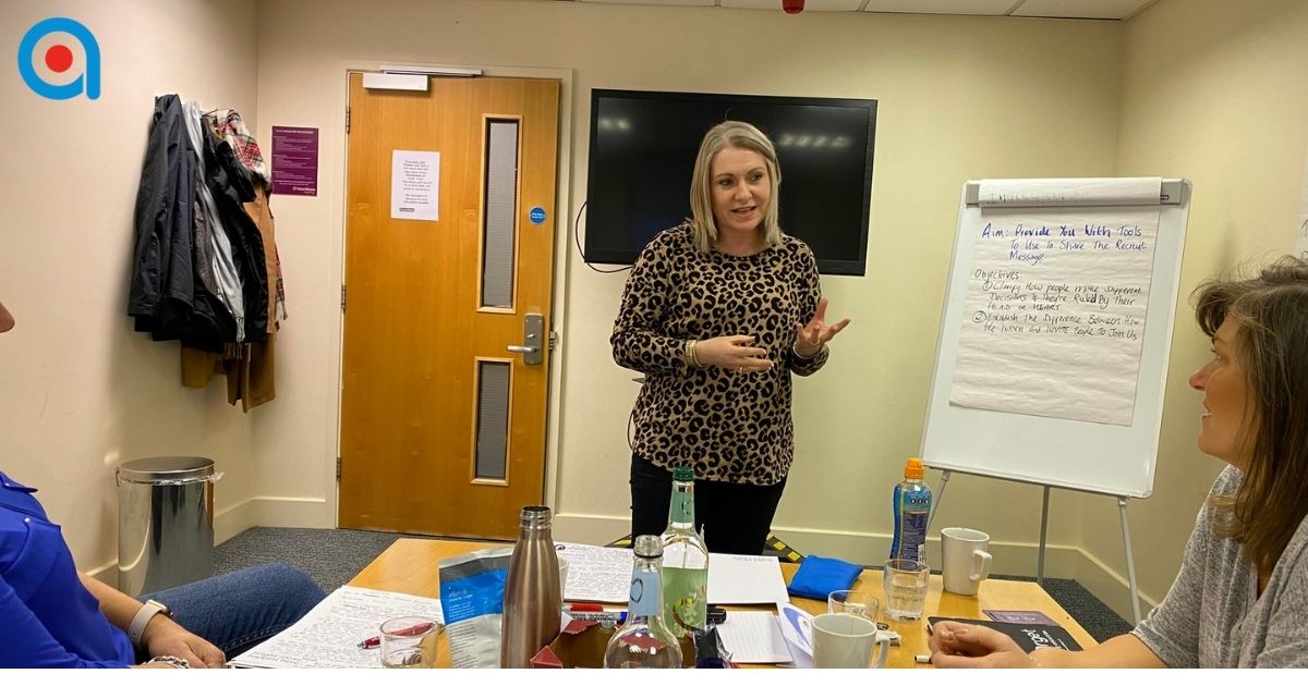 Trainer supporting a delegate during training practice.